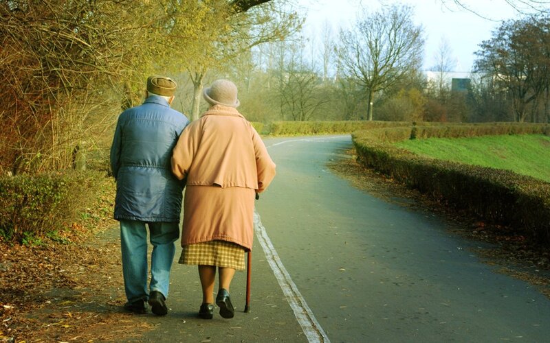 elderly couple walking in park