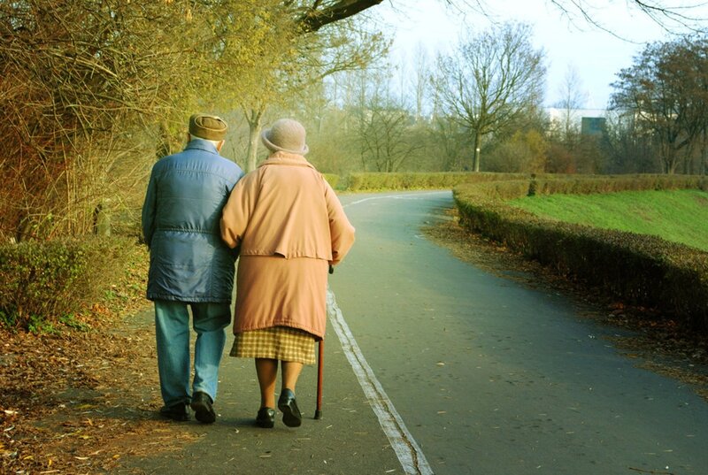 elderly couple walking in park