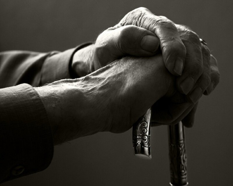 elderly hands holding a cane