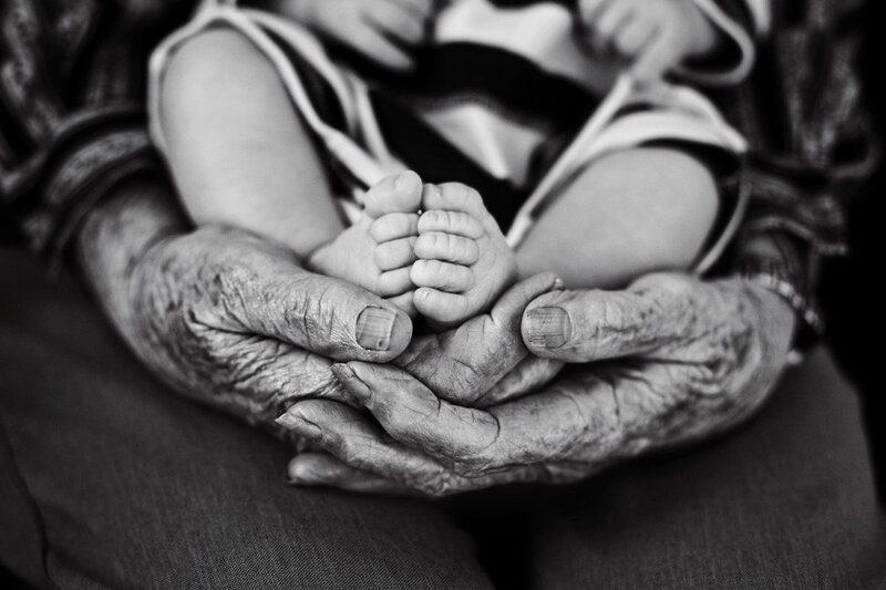 Elderly Hands Holding Baby Feet