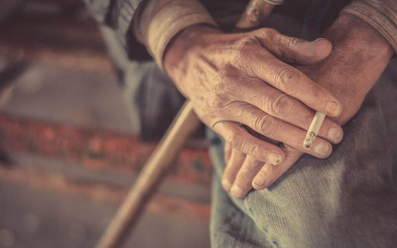elderly hands holding cigarette