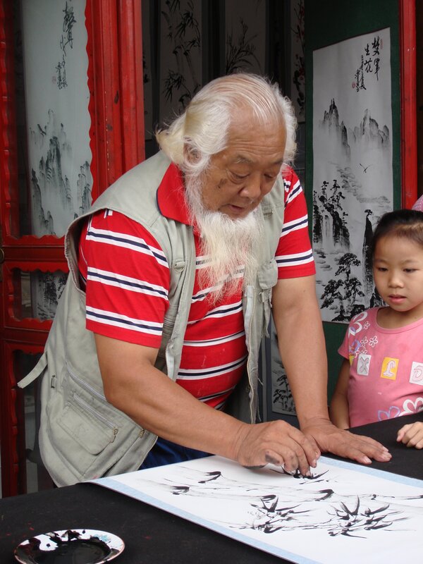 elderly man doing calligraphy