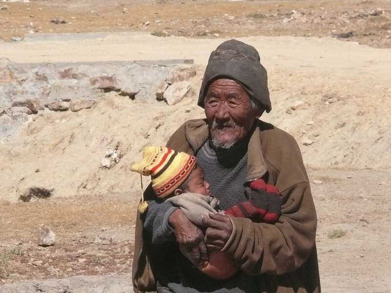 Elderly man holding a baby