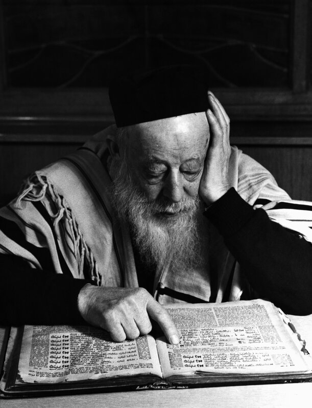 elderly man reading religious text