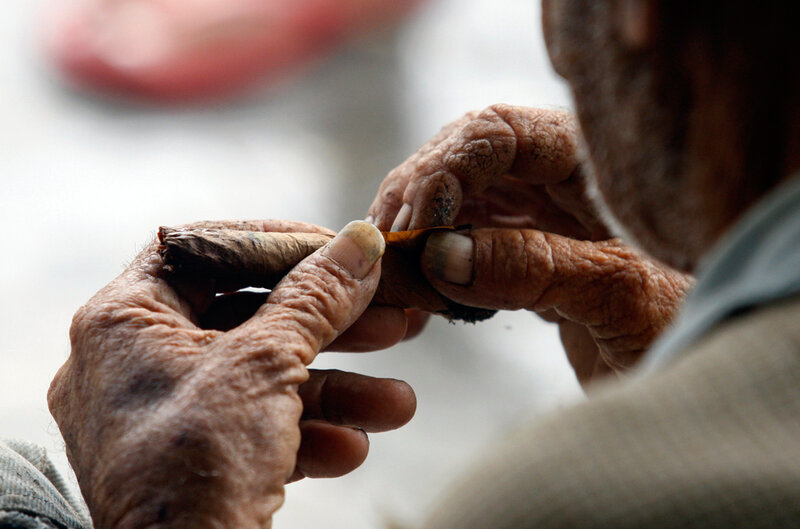 elderly man rolling a cigarette