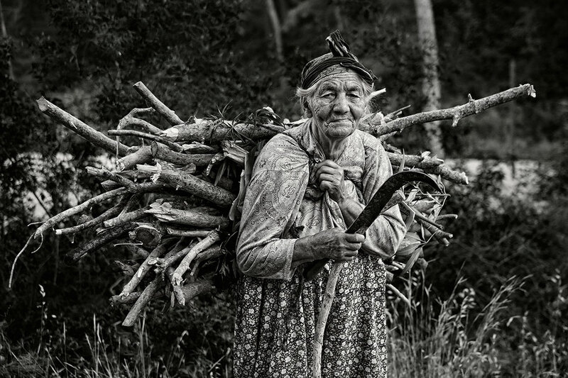 Elderly Woman Carrying Firewood
