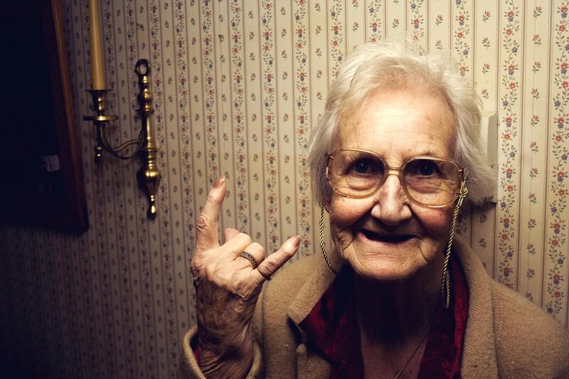 elderly woman making rock gesture