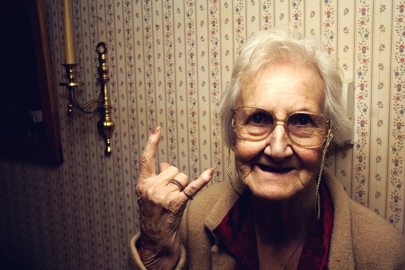 elderly woman making rock on hand