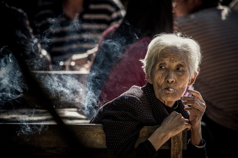 elderly woman smoking outdoors