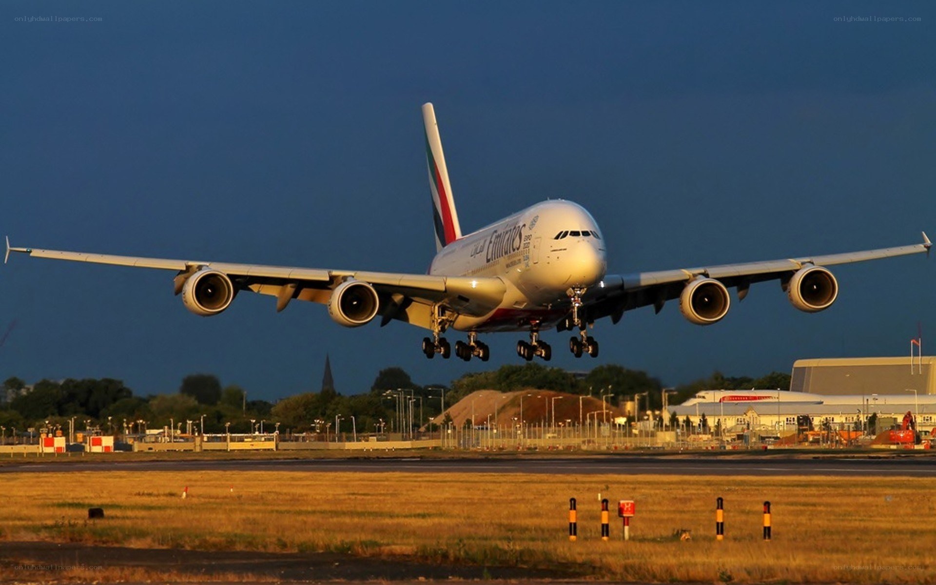 Emirates A380 landing at sunset