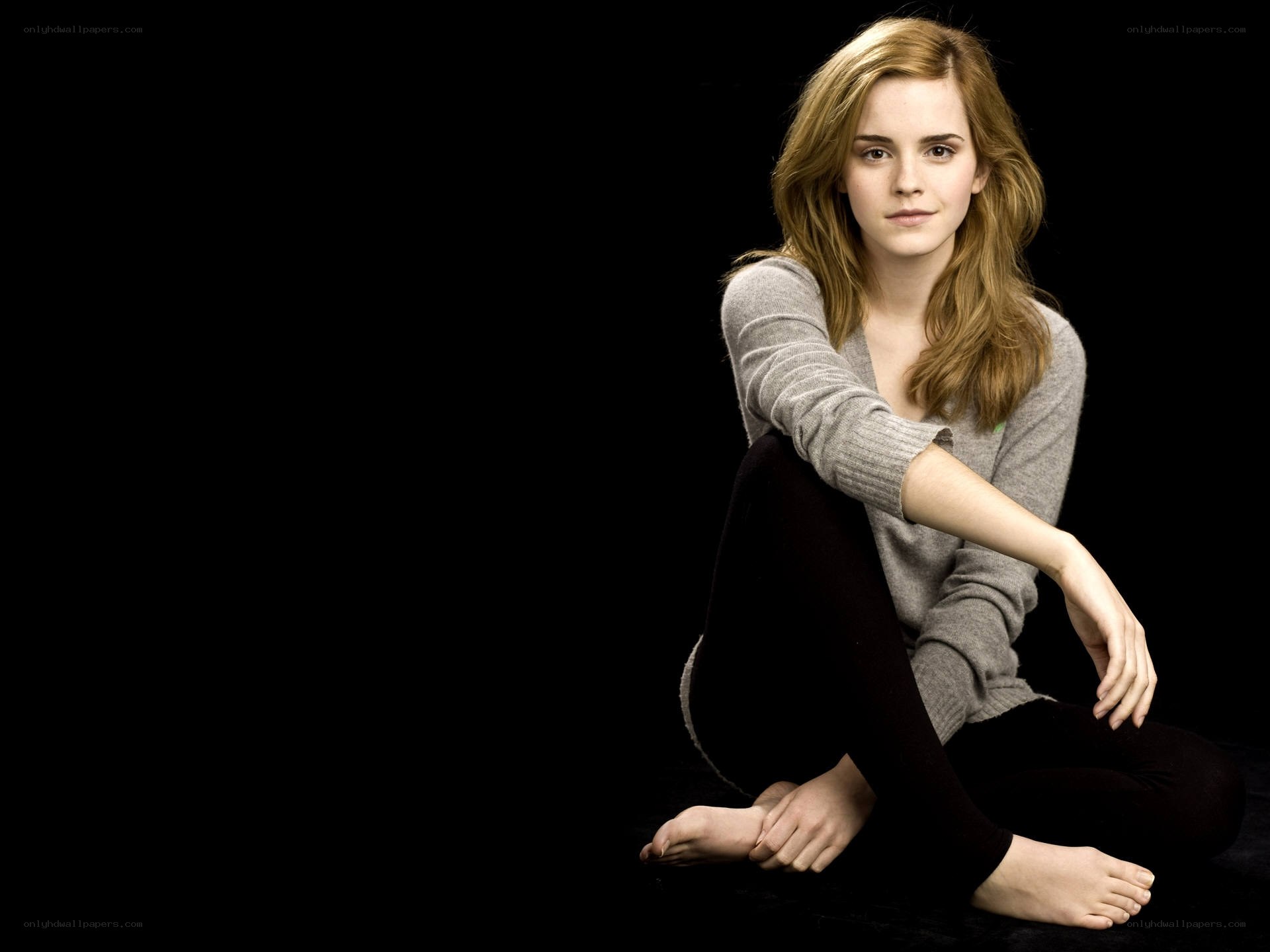 Emma Watson sitting on black background