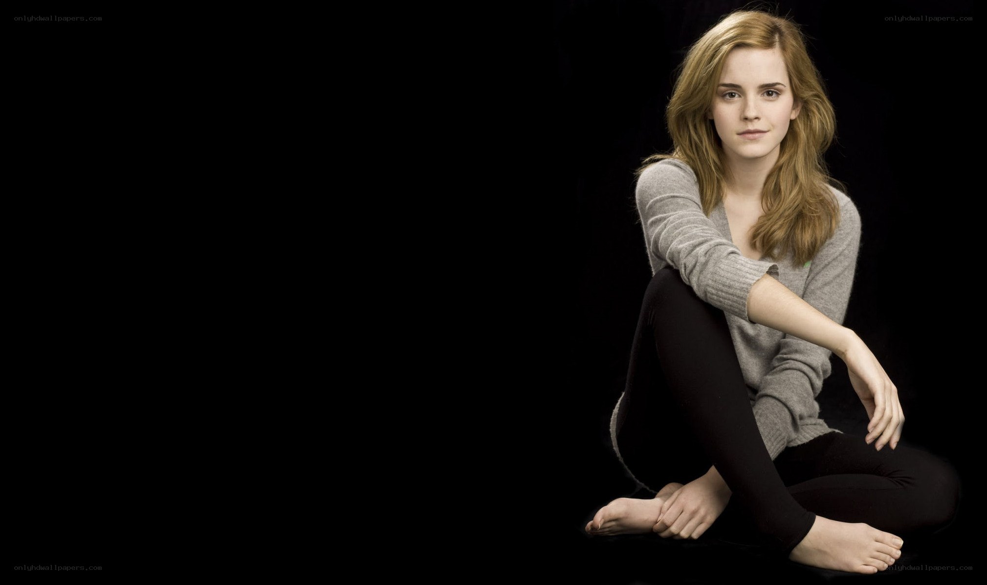 Emma Watson sitting on black background