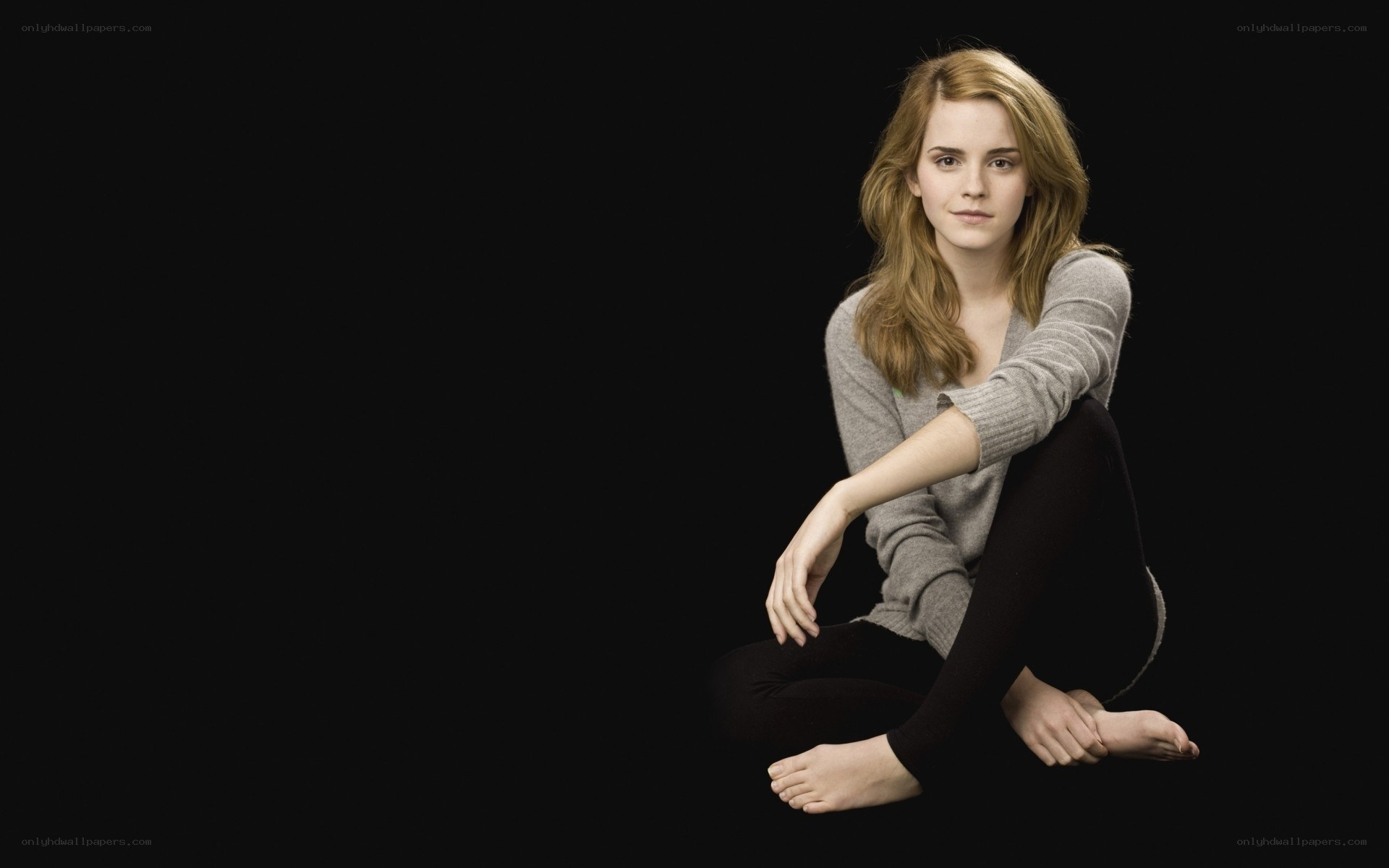 Emma Watson sitting on black background