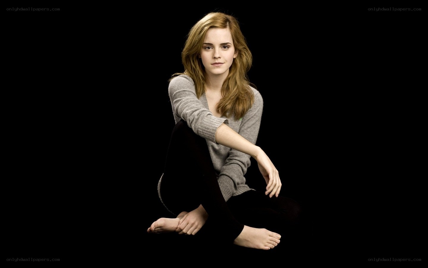 Emma Watson sitting on black background