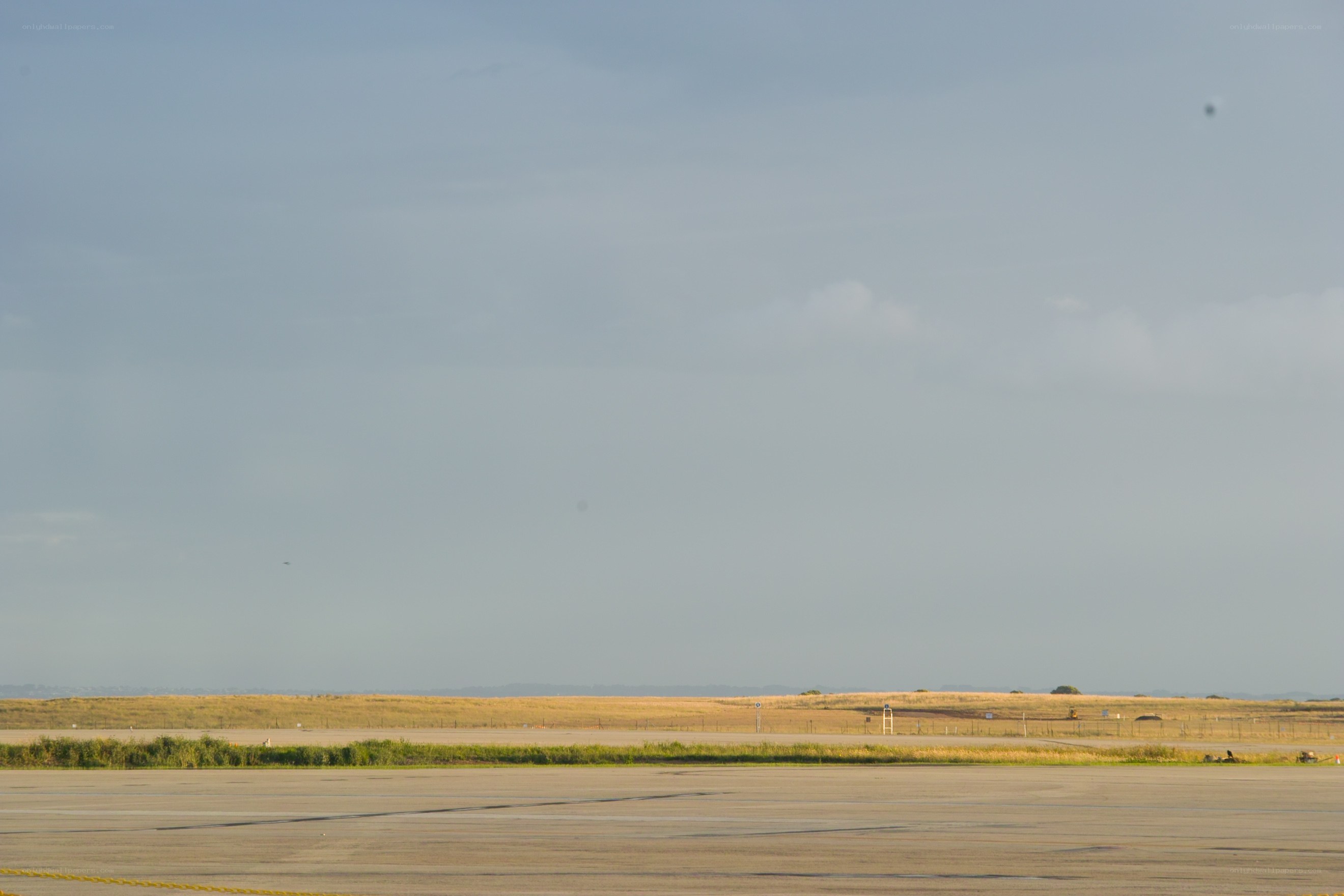Empty airfield under cloudy sky