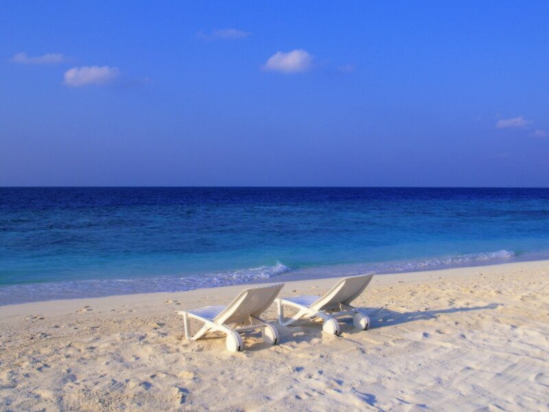 Empty beach chairs on a tropical shore
