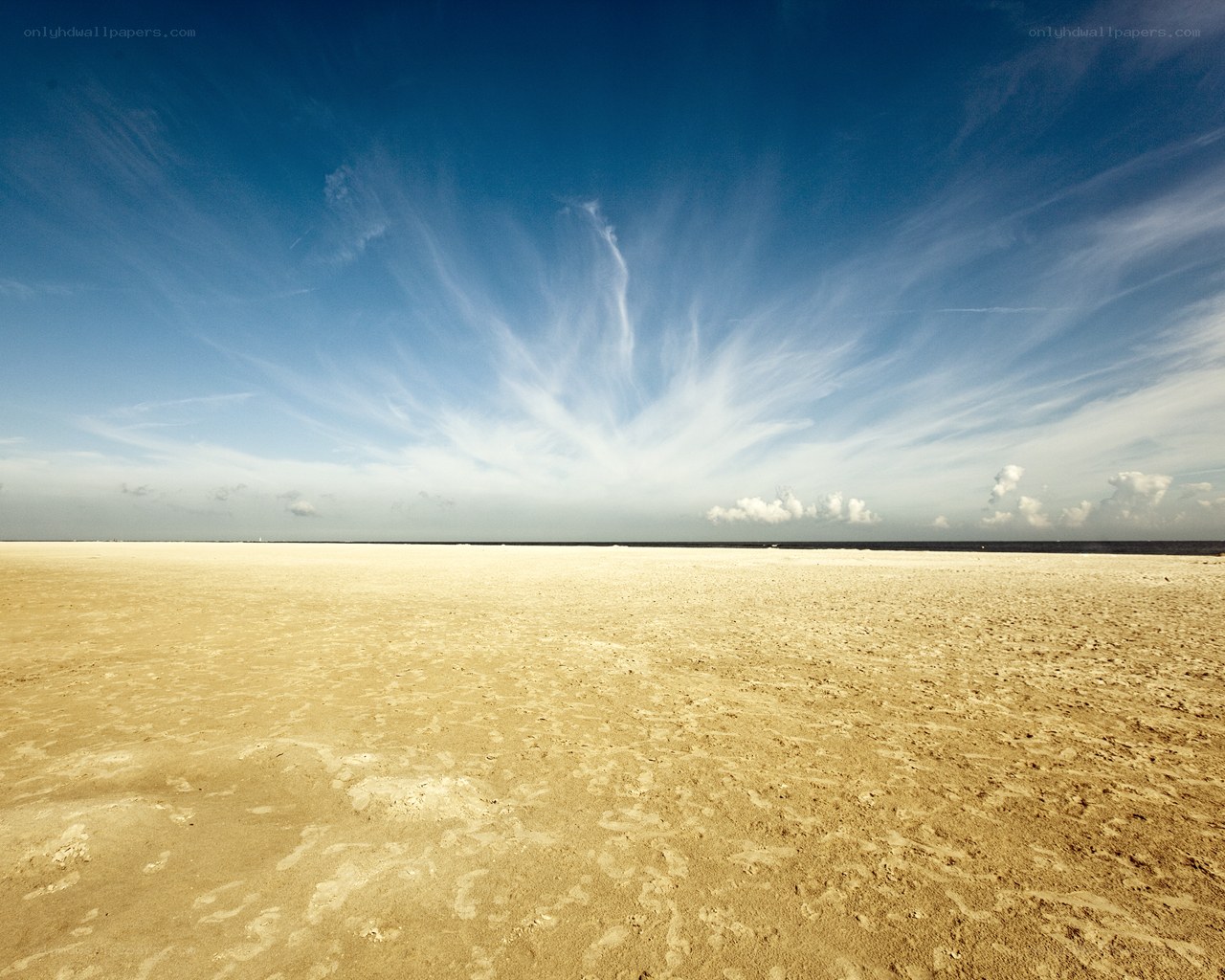 Empty beach under blue sky