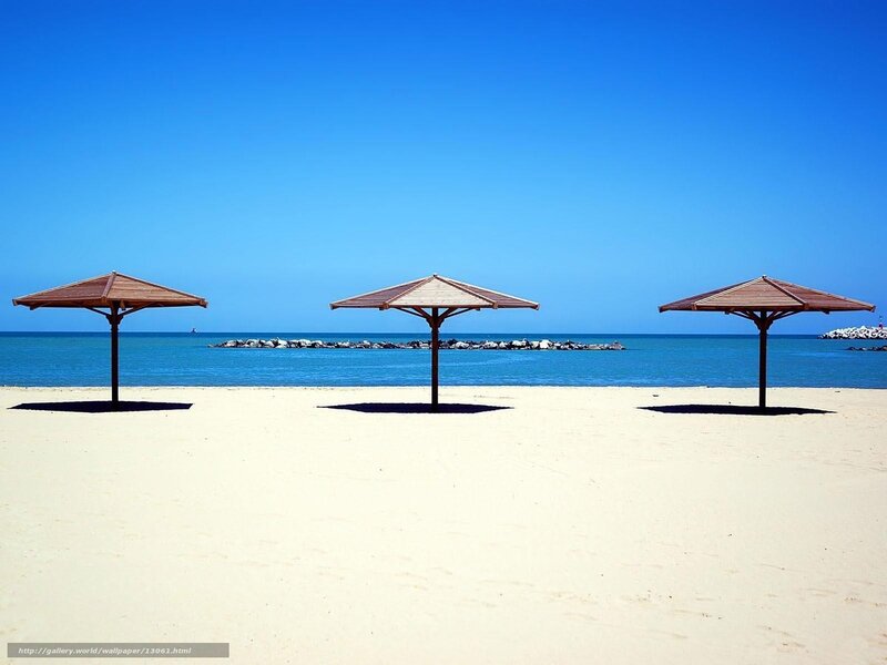 Empty beach with three umbrellas