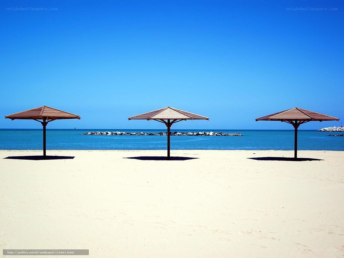 Empty beach with three umbrellas