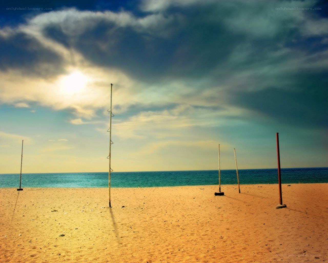 Empty beach with volleyball poles