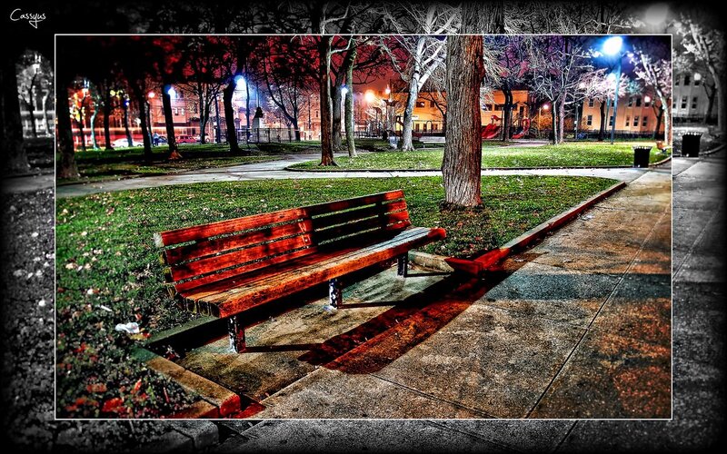 Empty bench in park at night