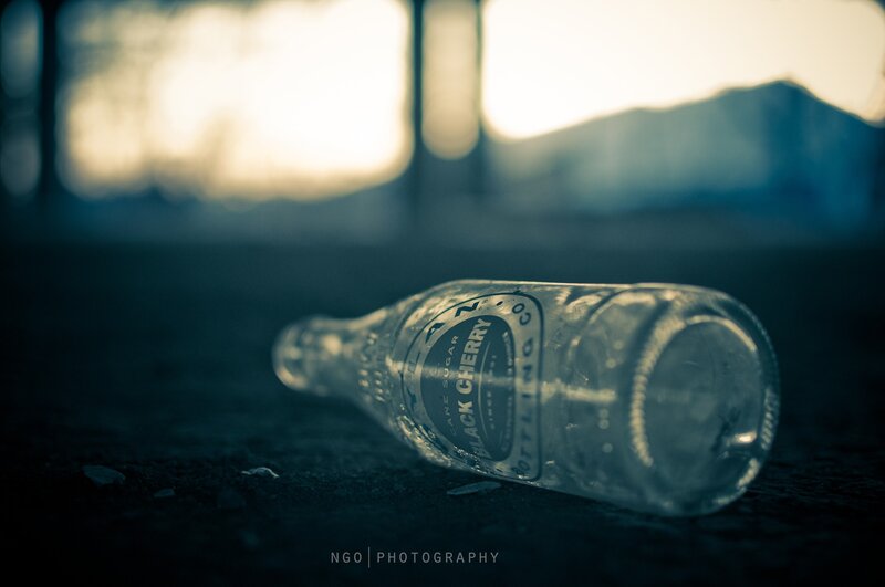 Empty bottle on ground at dusk