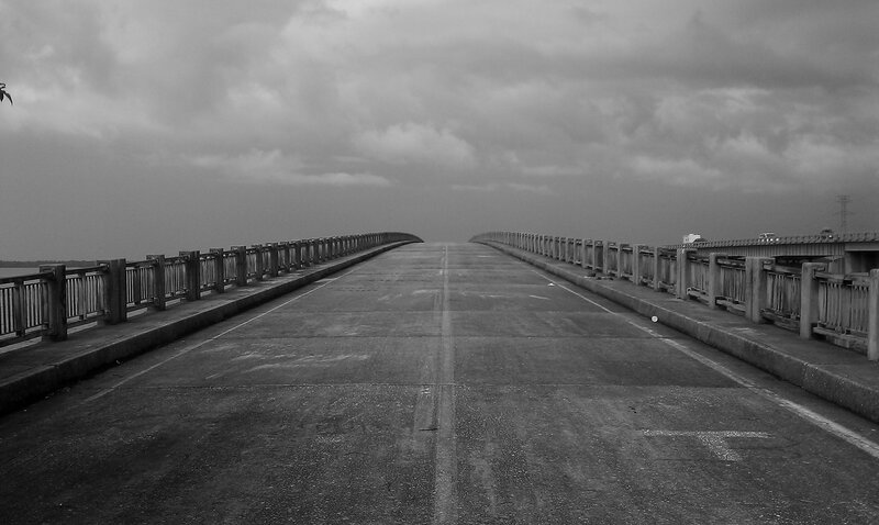 Empty bridge under cloudy sky