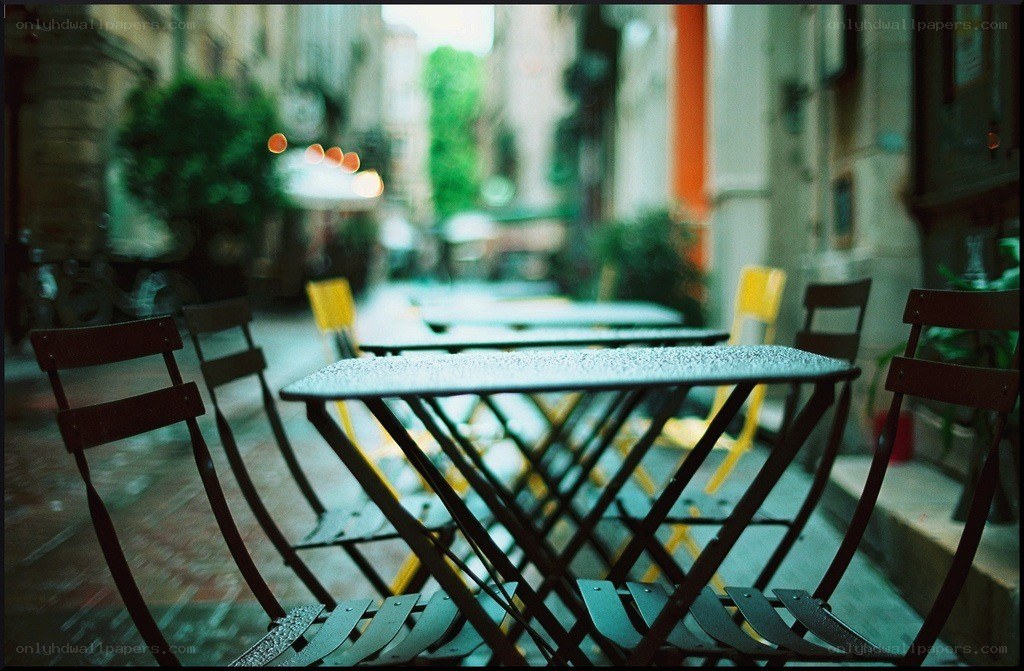 Empty cafe tables on a rainy street