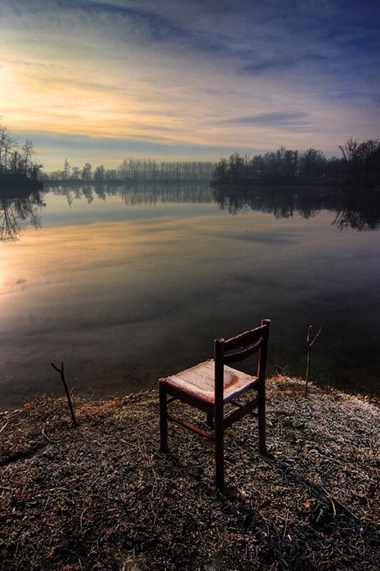 Empty chair by the lake at sunset