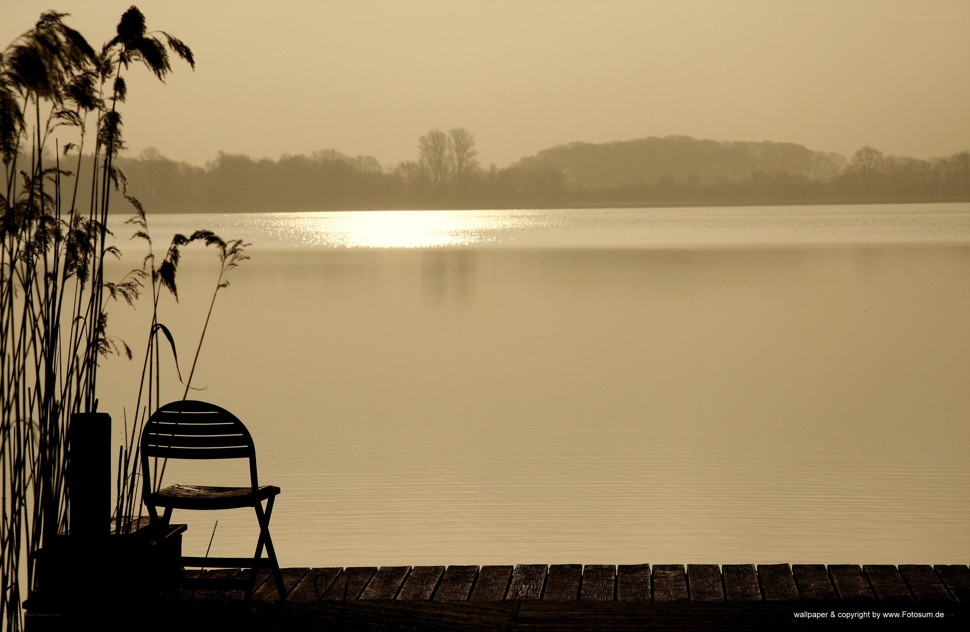 Empty chair by the lake