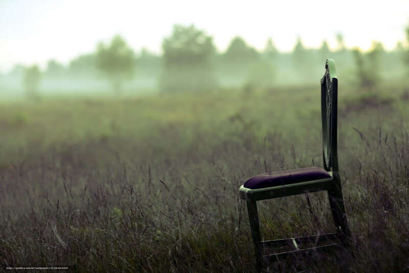 Empty chair in a misty field