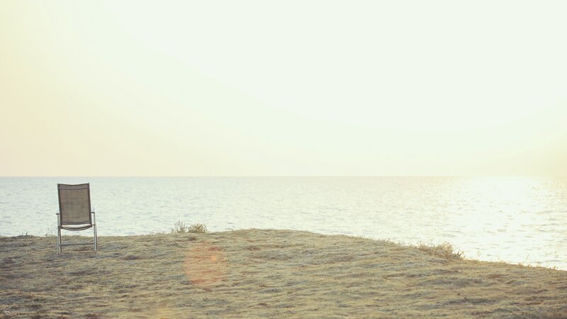 Empty chair on a beach at sunset