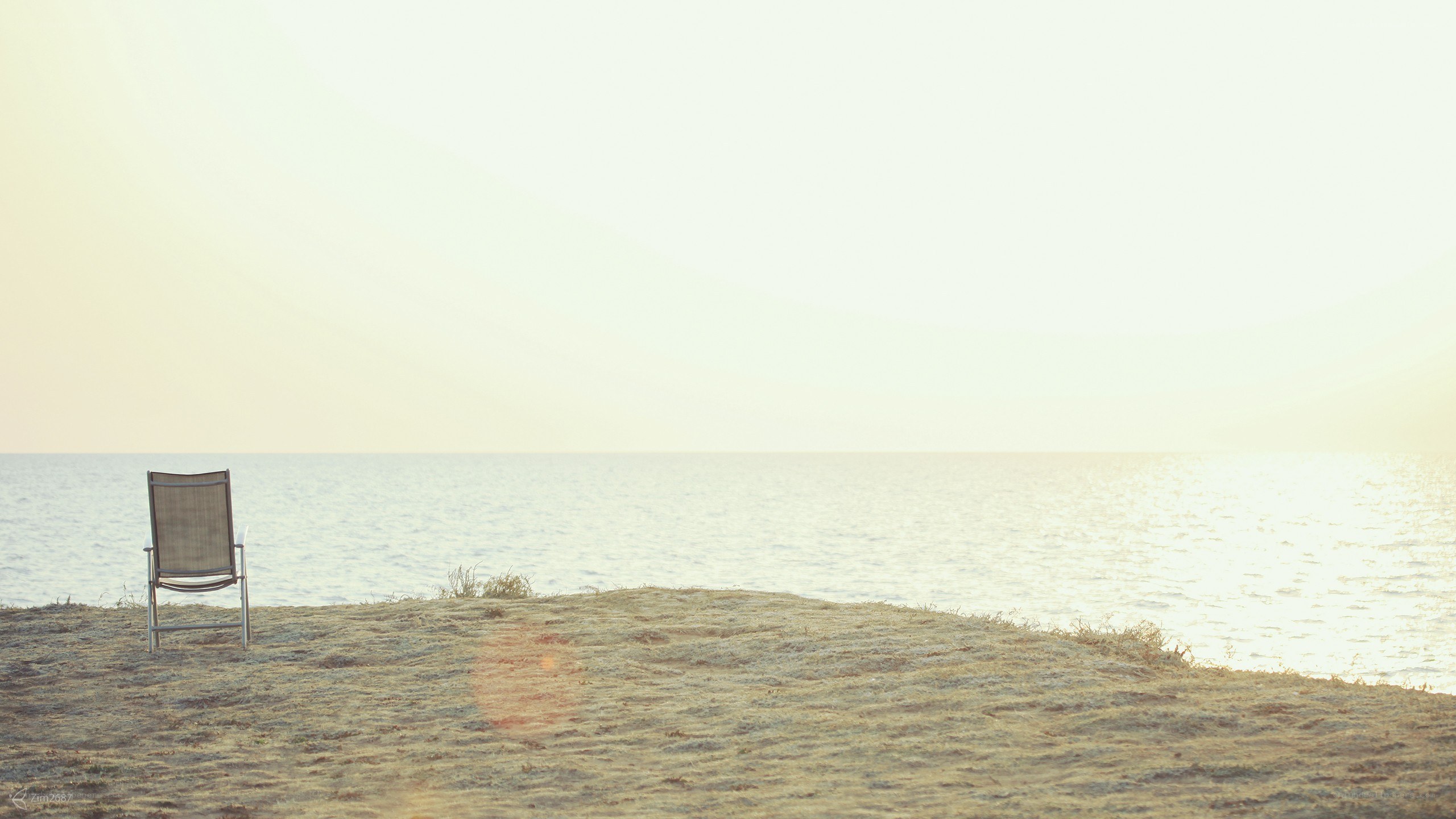 Empty chair on a beach at sunset