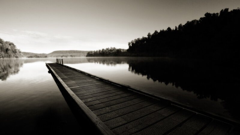Empty dock on a misty lake