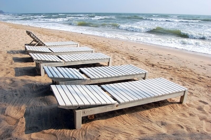 Empty lounge chairs on a sandy beach