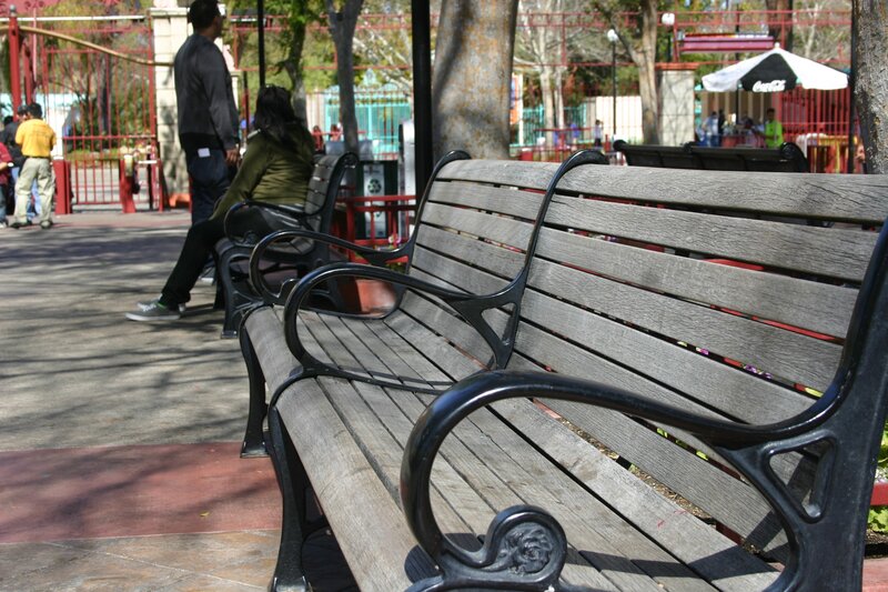 Empty park bench in public area