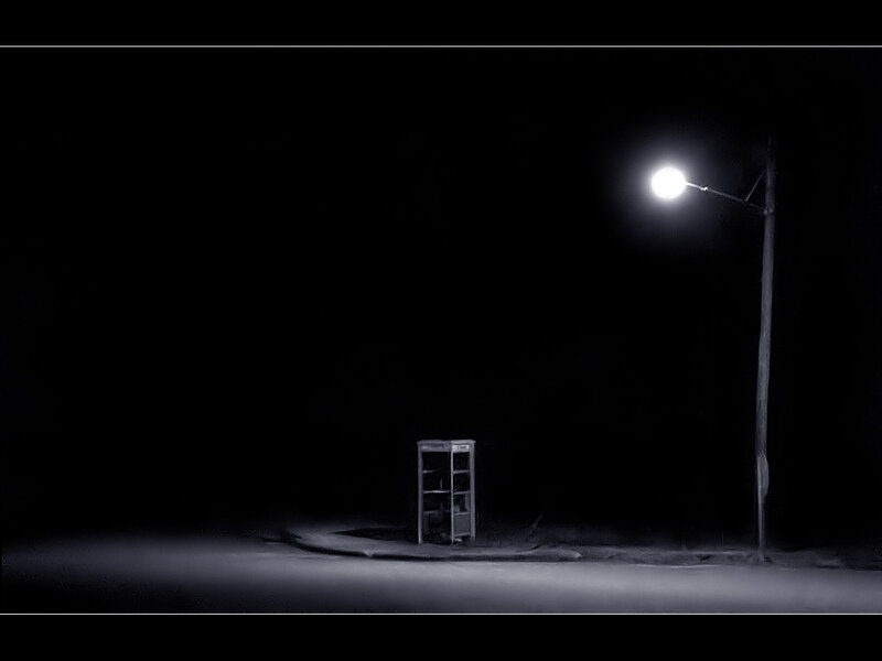 Empty phone booth under streetlight