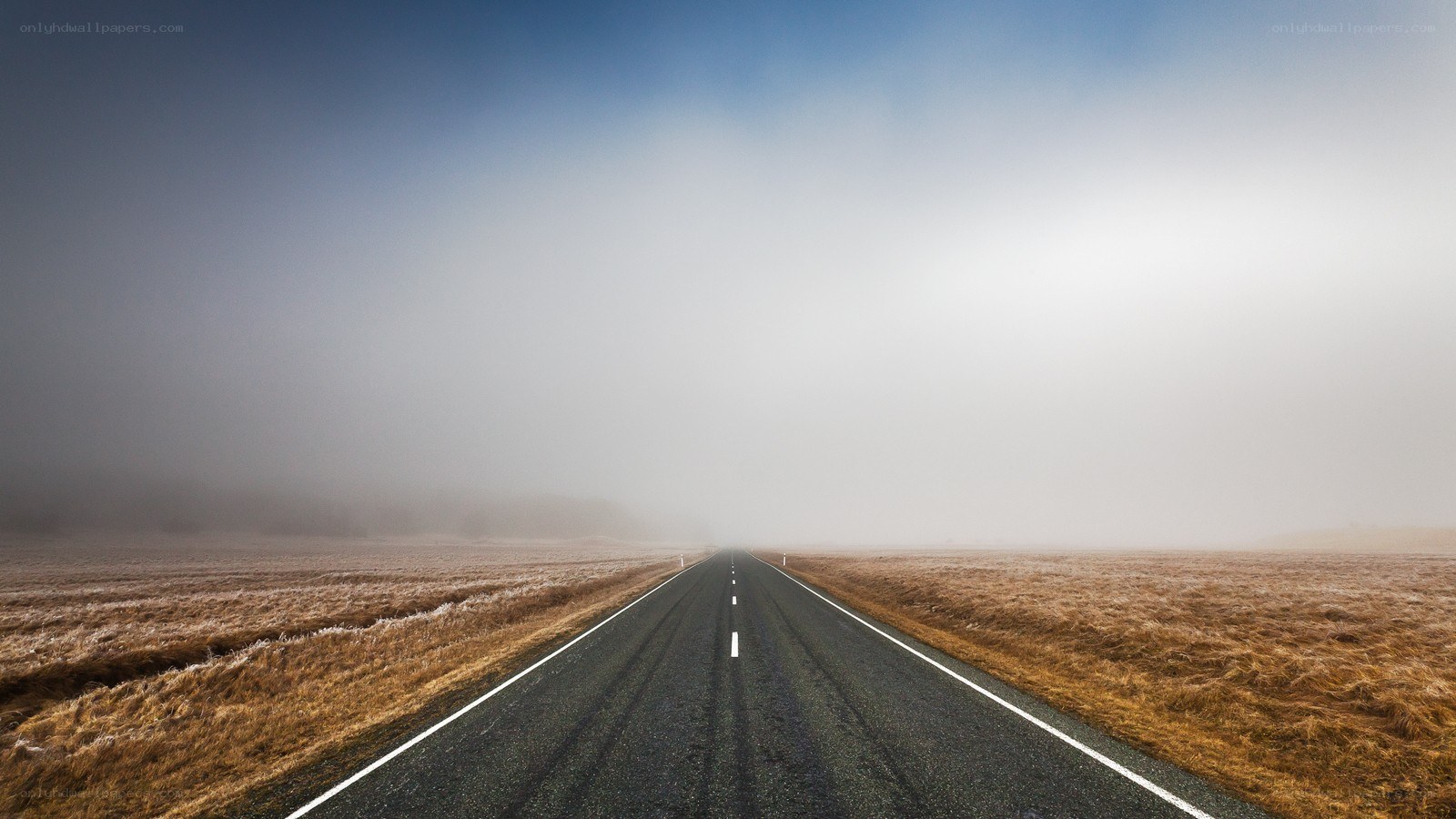 Empty road in foggy landscape
