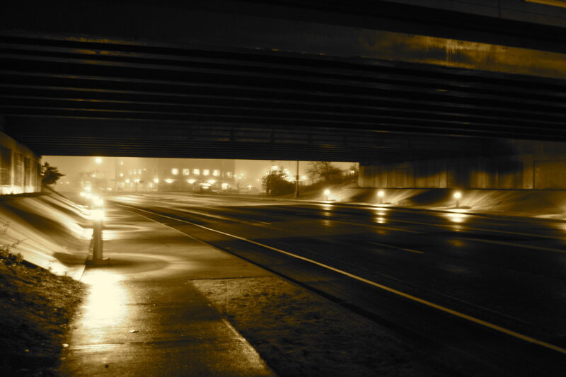 Empty road under bridge at night