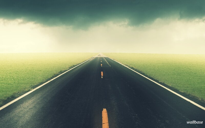 Empty road under stormy sky