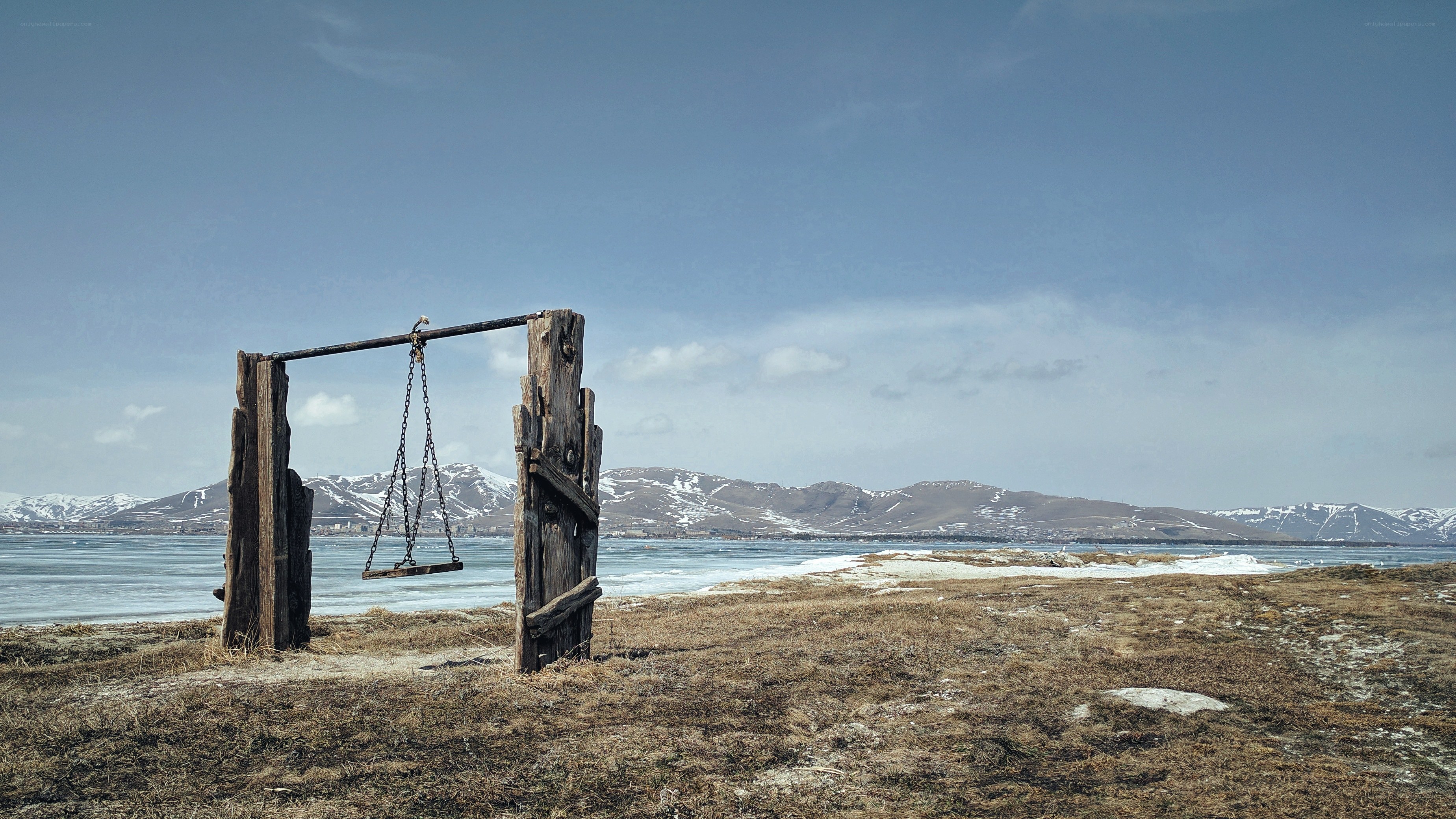 Empty swing by frozen lake