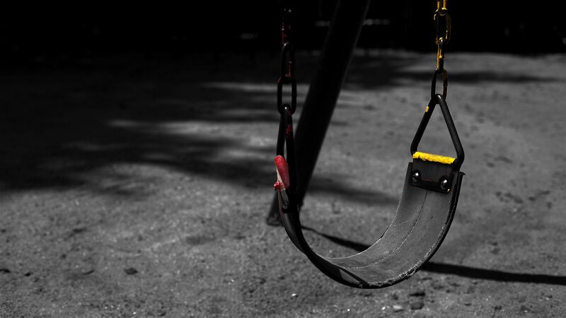 Empty swing in dark playground