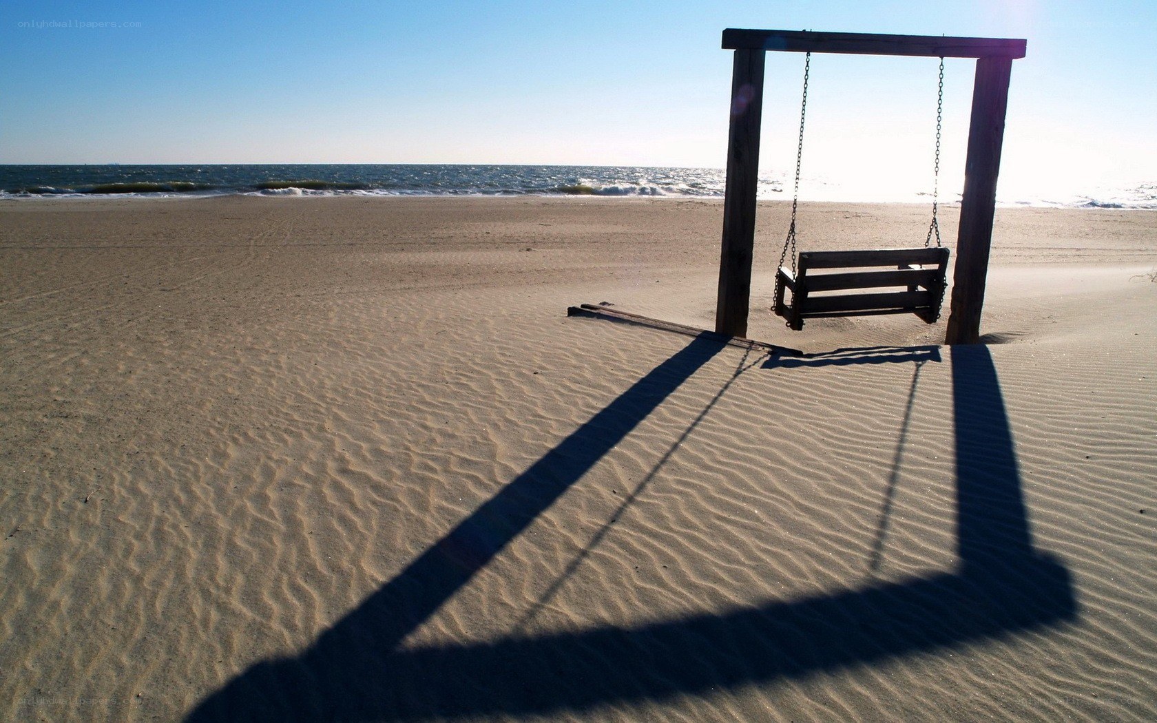 Empty swing on a sandy beach