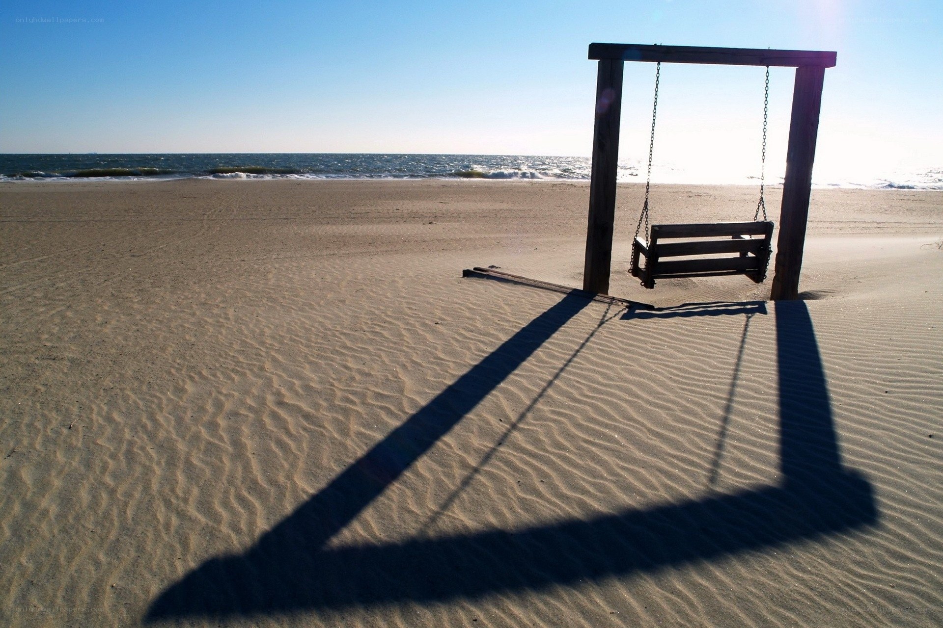 Empty swing on a sandy beach