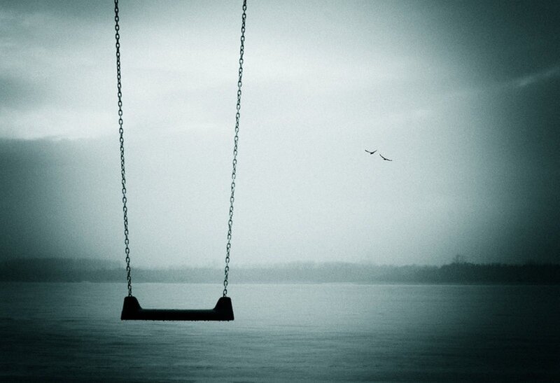Empty swing over water