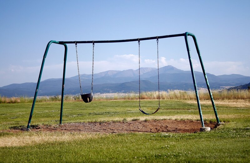 Empty swings with mountains