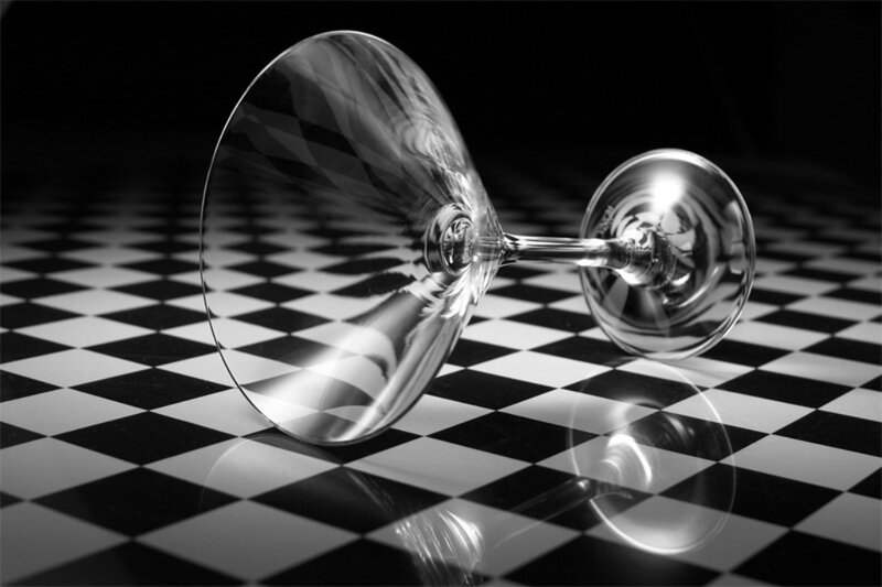 Empty wine glass on checkered surface