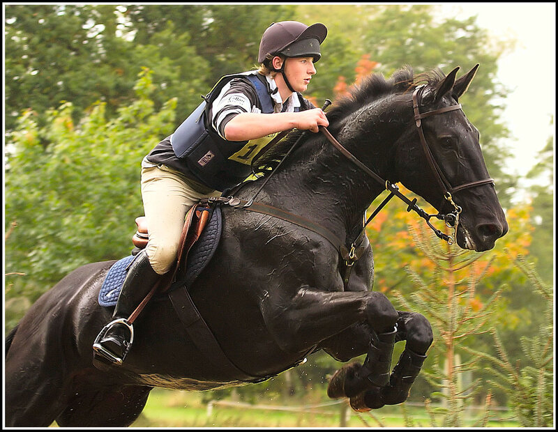 Equestrian jumping a horse