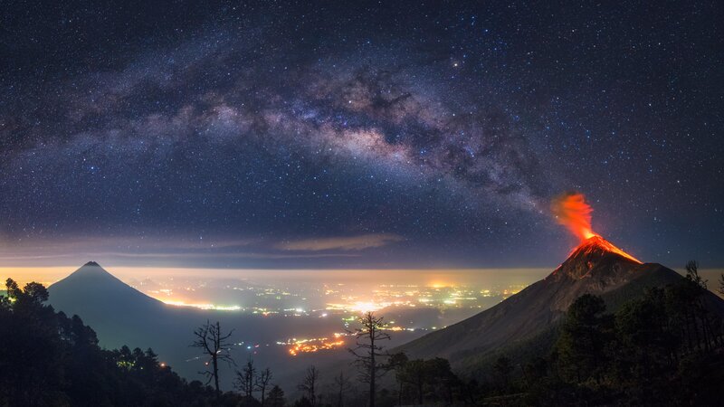 Erupting Volcano at Night — Black, Dramatic, Photograph, Milky Way, City Lights