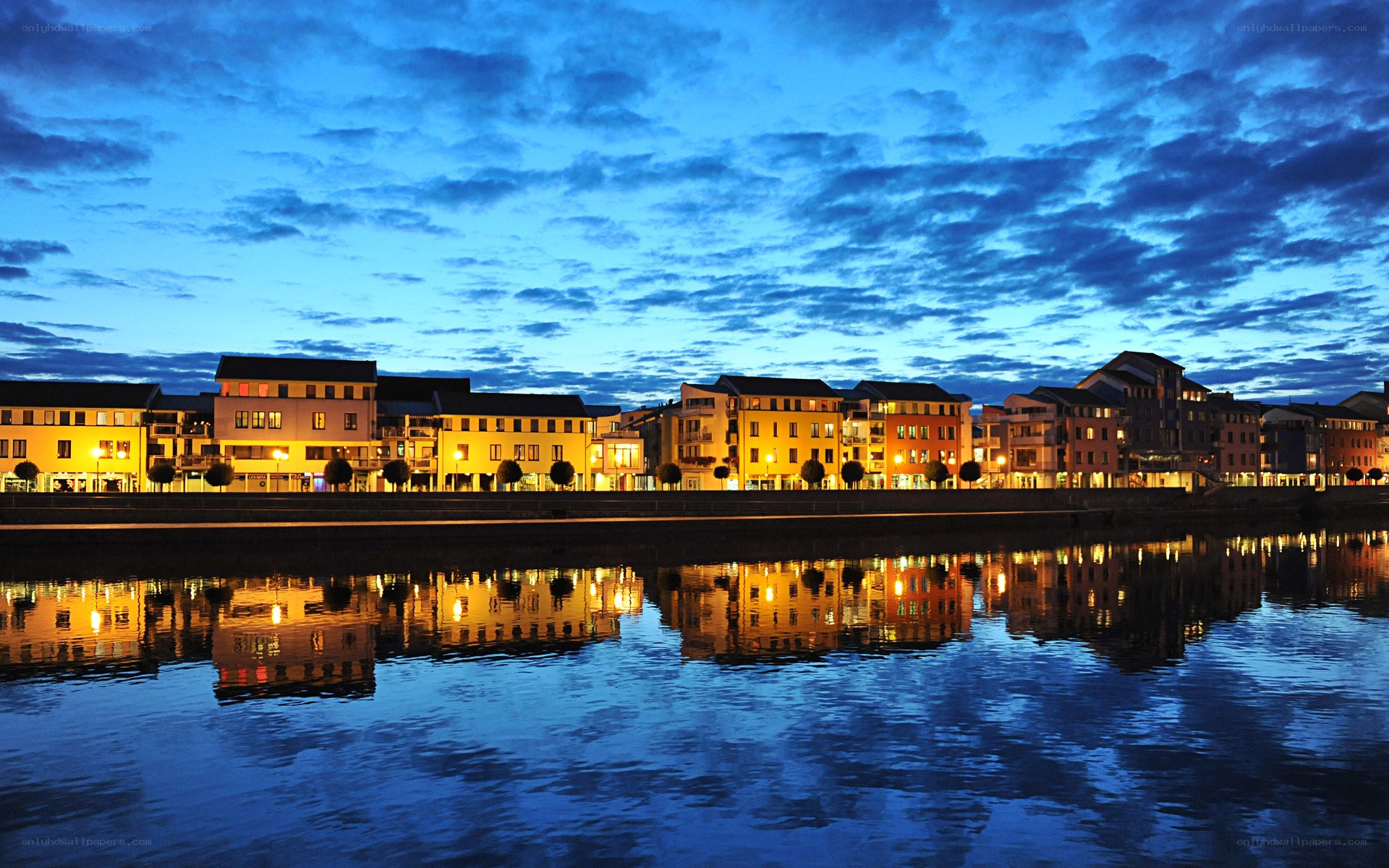 Evening lights on riverfront buildings